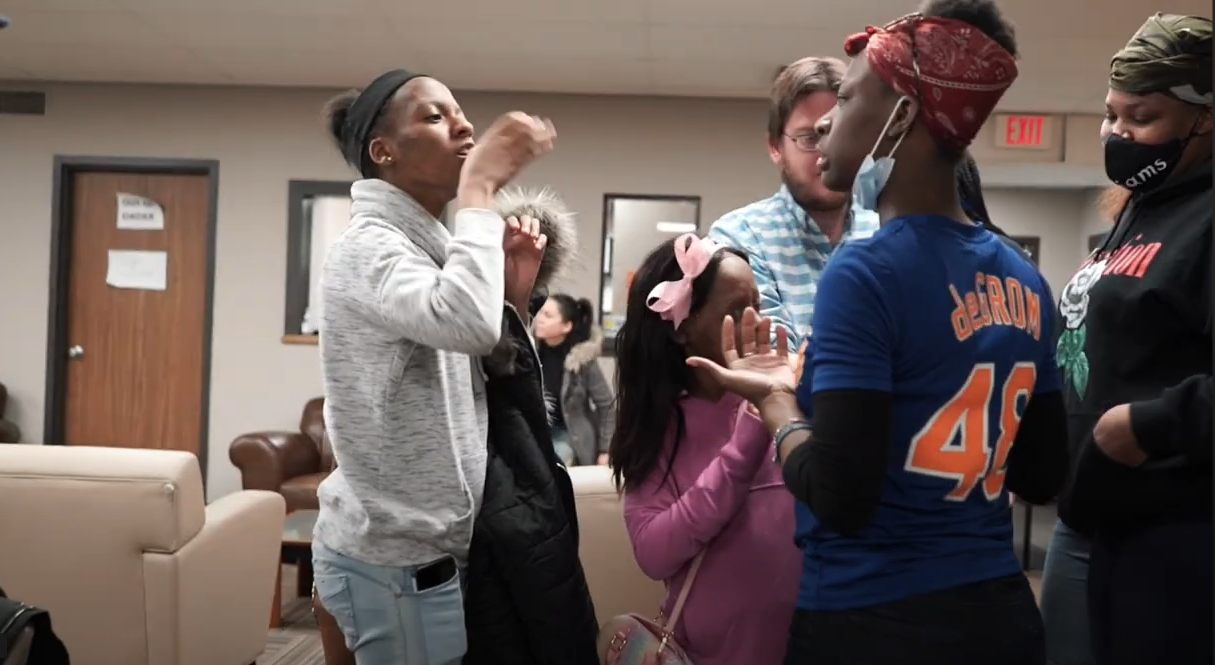 a group of teenage girls signing to each other